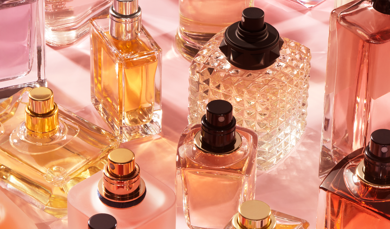 Parfymeflasker med rosa bakgrund